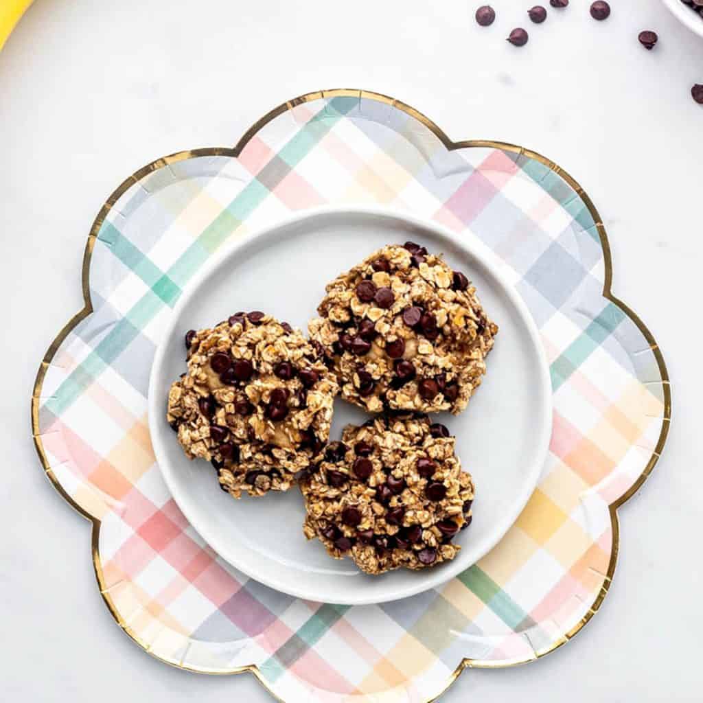 Three 3-ingredient cookies with banana on a white and checkered plate.