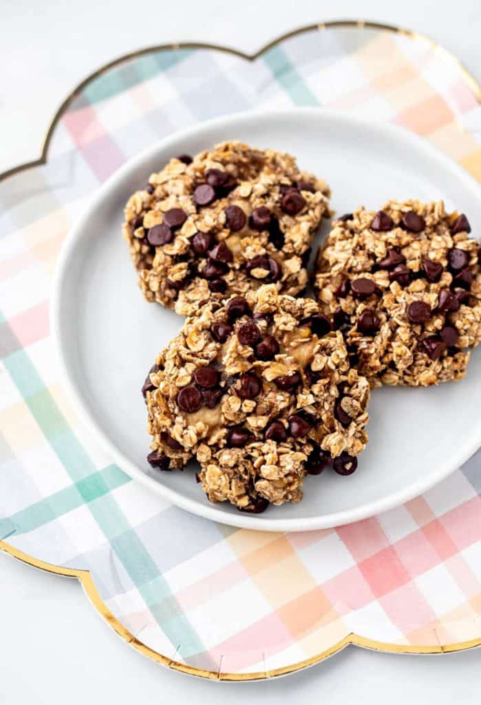 Healthy banana oat cookies on a white and plaid plate with chocolate chips.