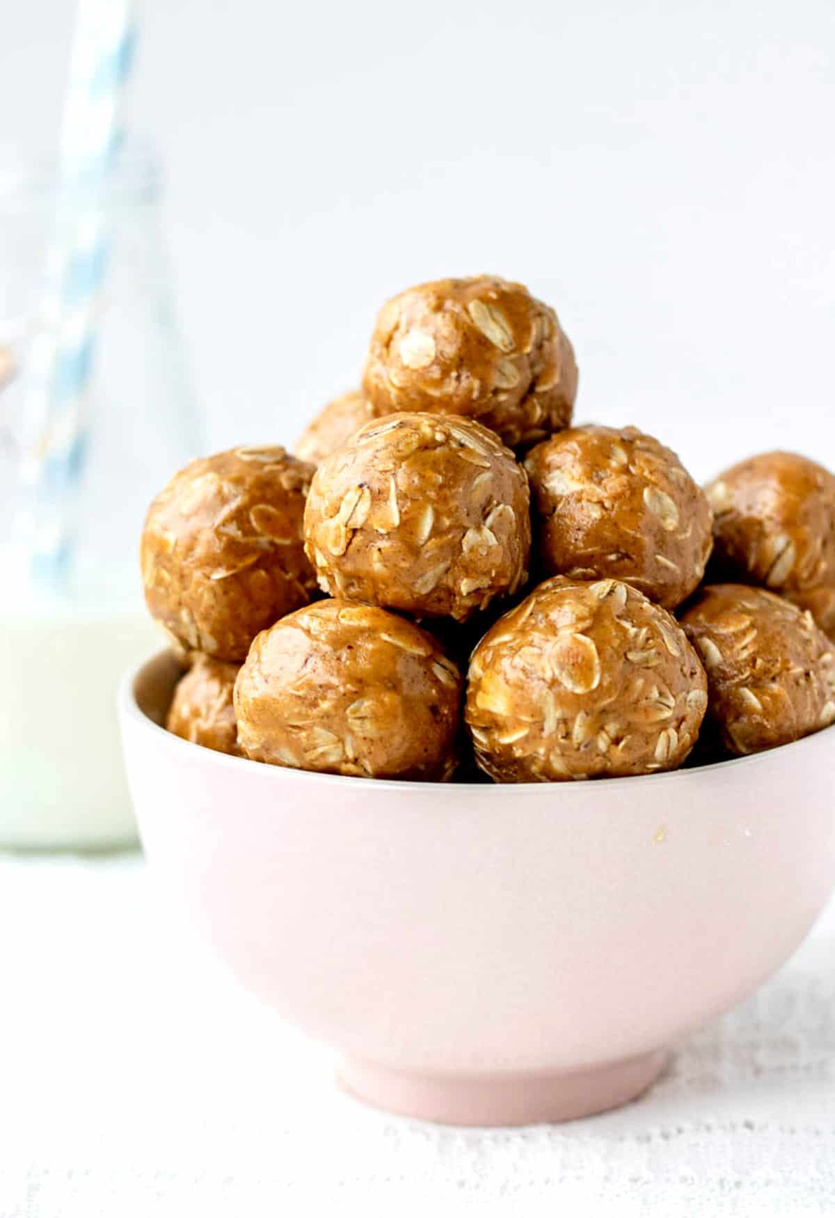 Peanut butter oat balls stacked in a pink bowl.
