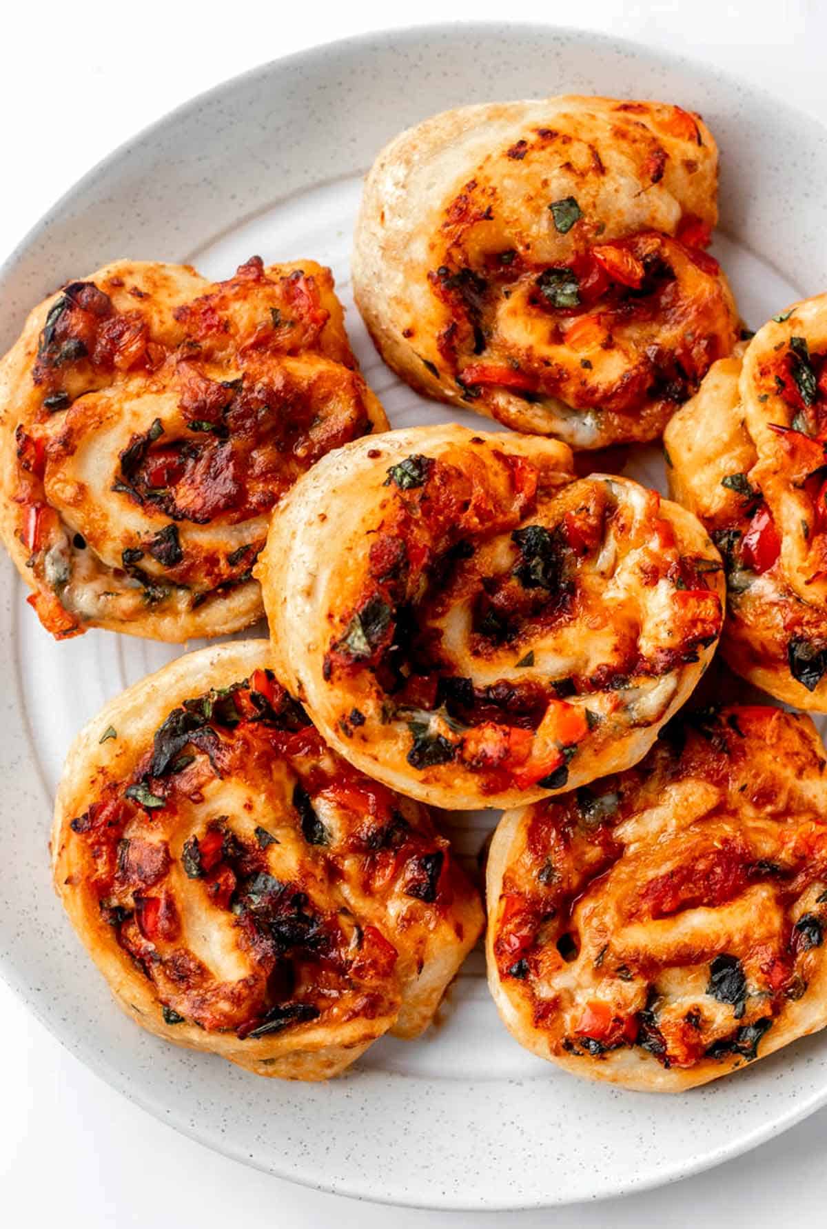 Close up of veggie-packed air fryer pizza rolls on a plate.