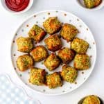 Air fryer veggie tots on a polka dot plate next to ketchup.