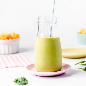 Green smoothie without yogurt or banana in a milk jug with a straw.