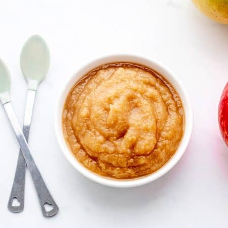 An overhead shot of sugar free applesauce next to two spoons.