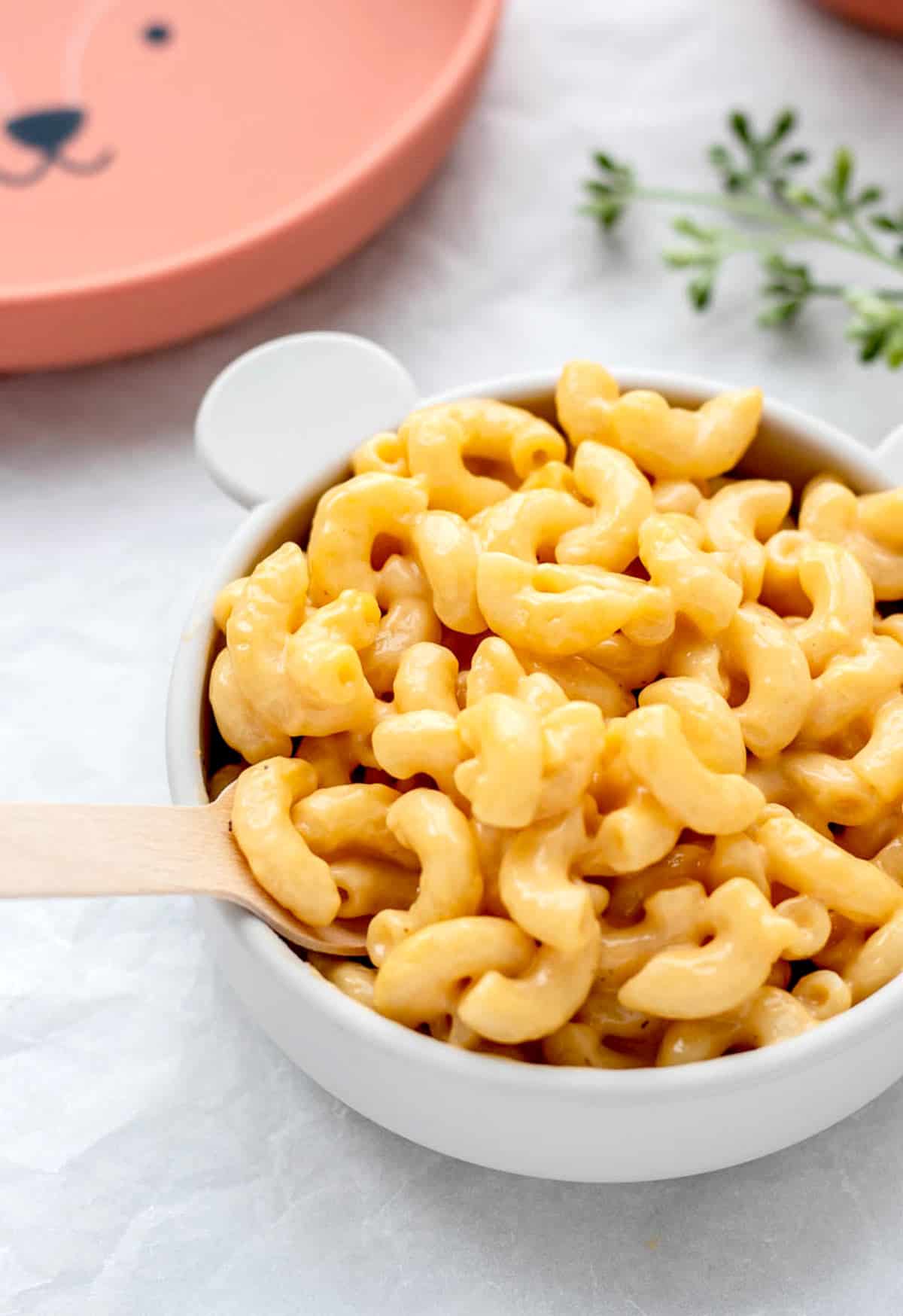 A fork digging into a bowl of creamy mac and cheese.