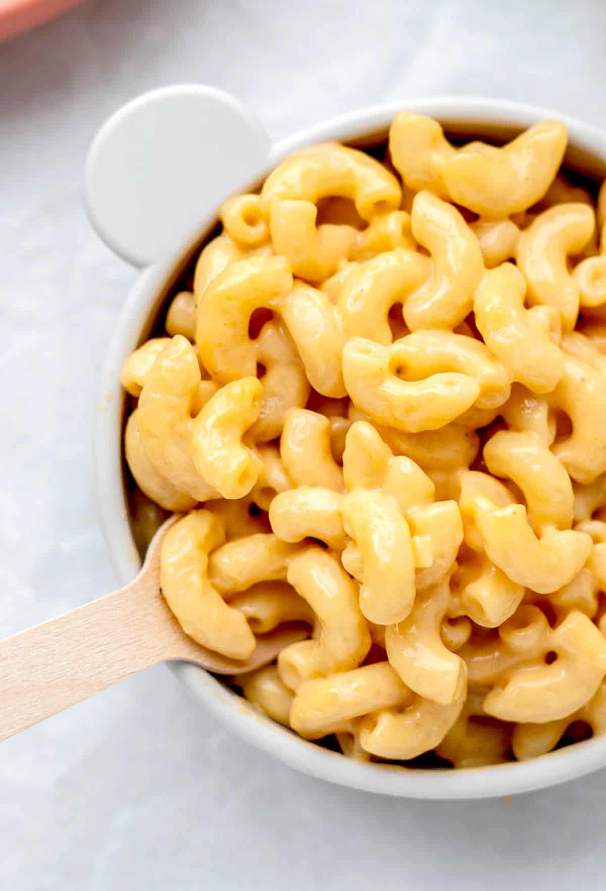 Close up of mac and cheese in a bowl with a fork in it.