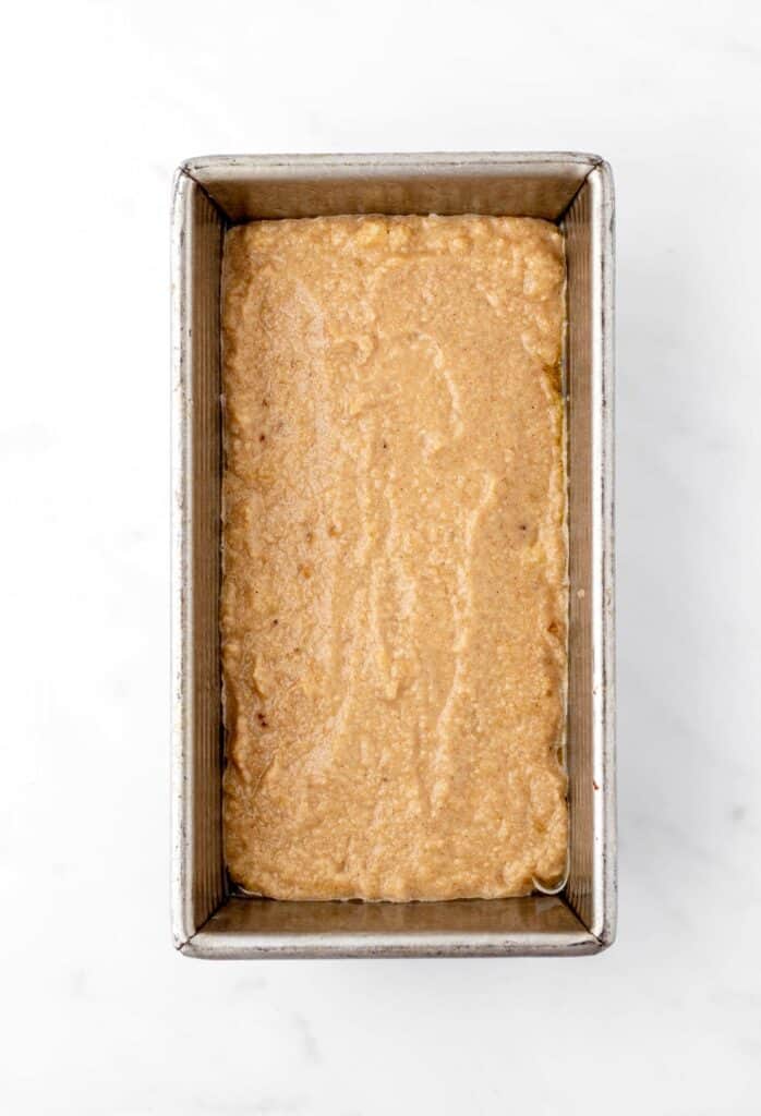 The banana bread batter in a loaf pan.