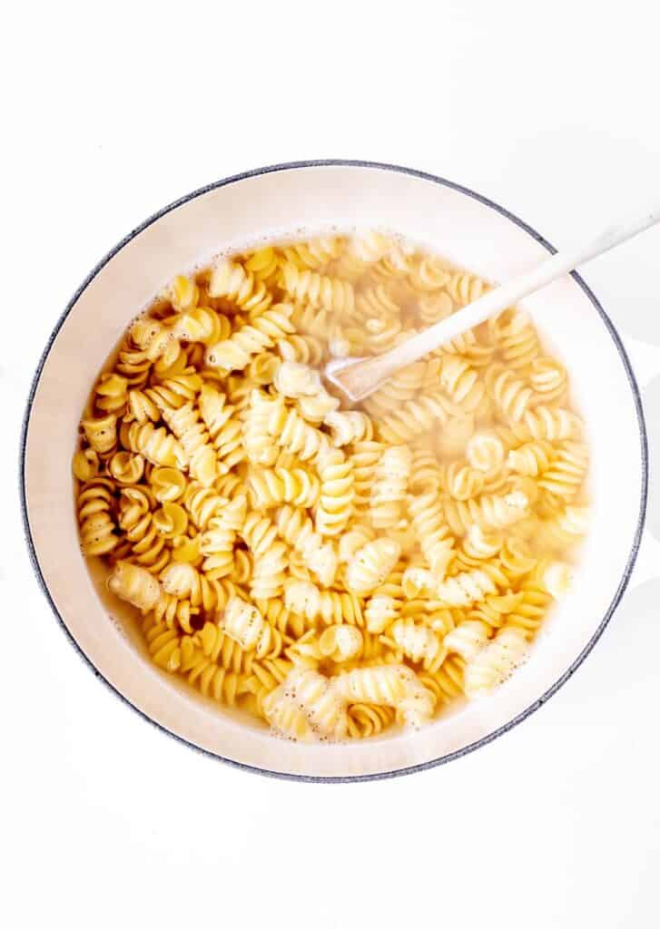 Rotini noodles cooking in a pot.