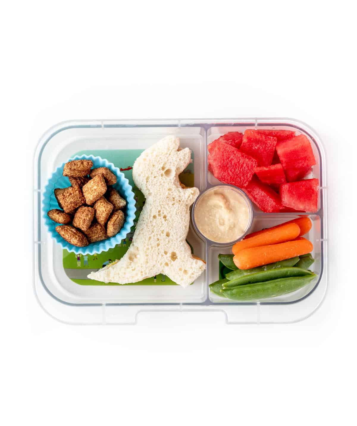 Dinosaur sandwich, whole whole grain cereal, watermelon and veggies in a lunch box.