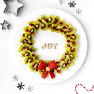 Christmas wreath with fruit on a plate with Christmas dcorations.