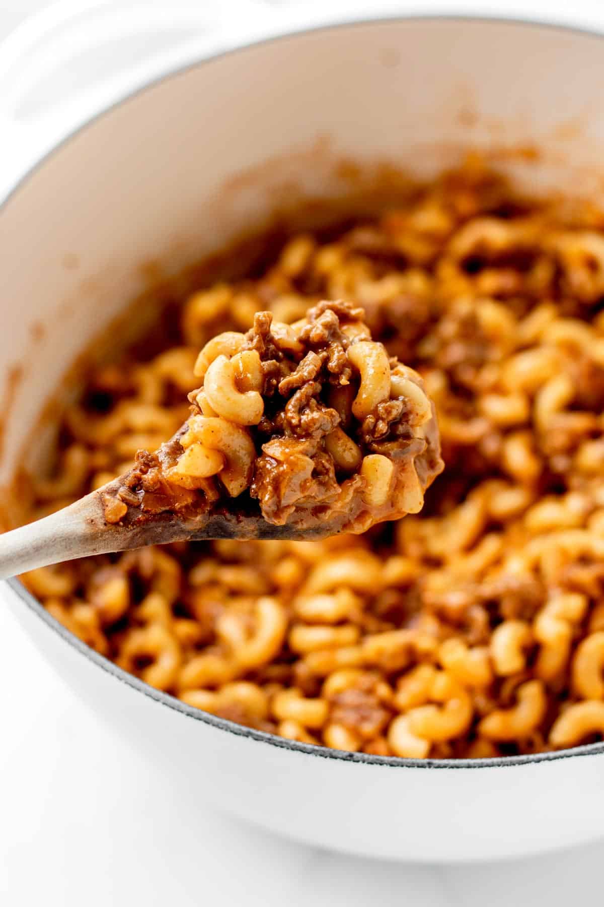 A wooden spoon holding up a scoop of healthy hamburger helper.