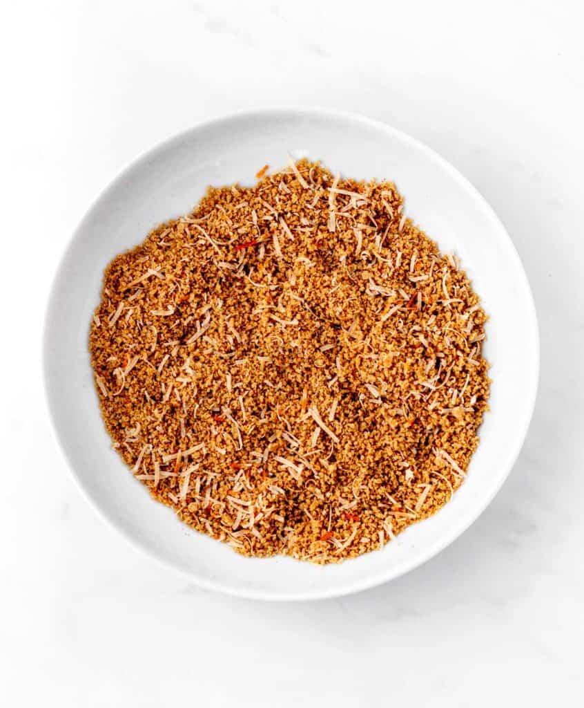 Bread crumbs, parmesan cheese and spices in a white bowl.