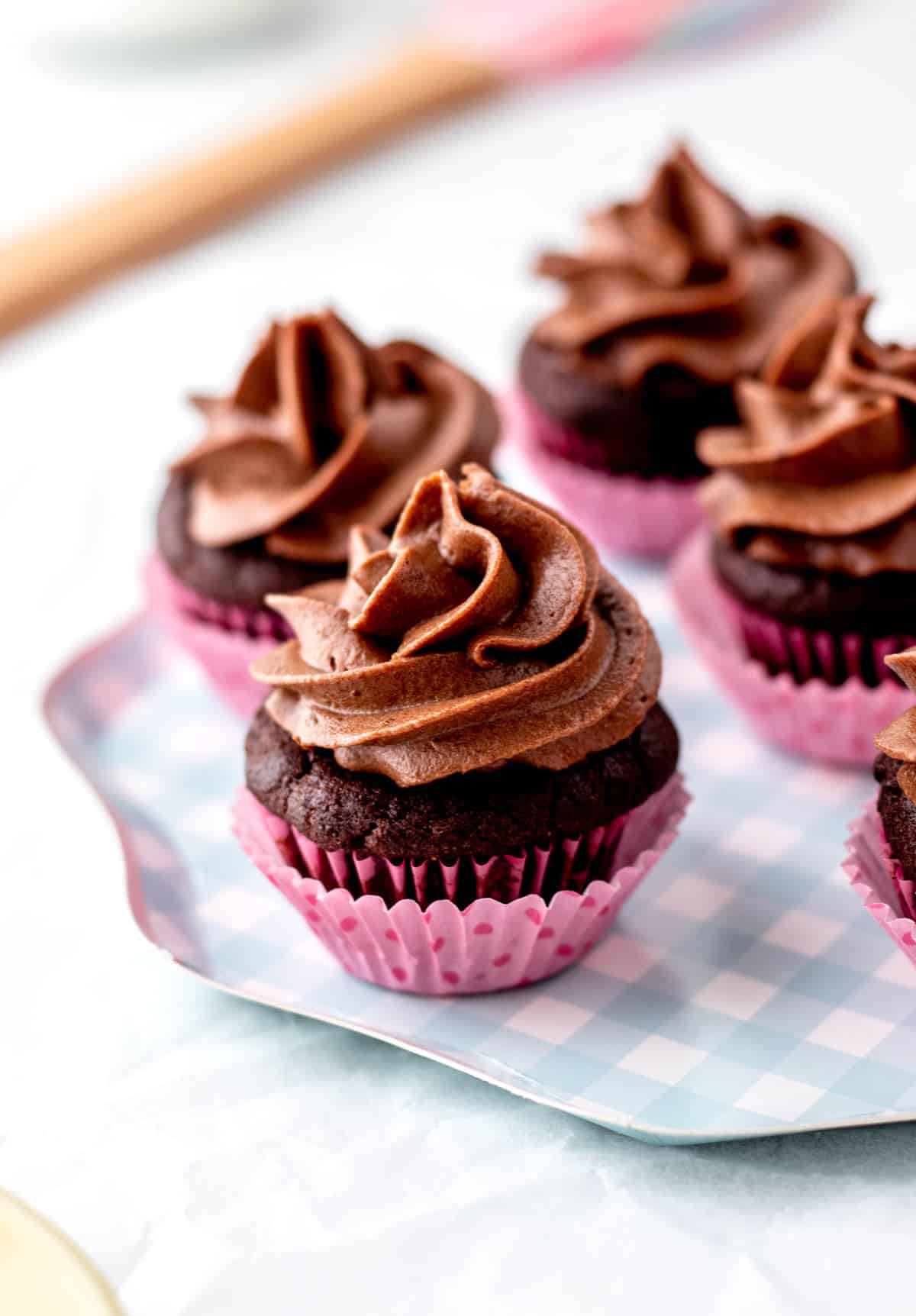 An up close image of healthy chocolate frosting without powdered sugar piped onto mini cupcakes.