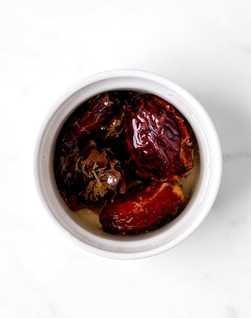 Dates being soaked in a bowl of hot water.