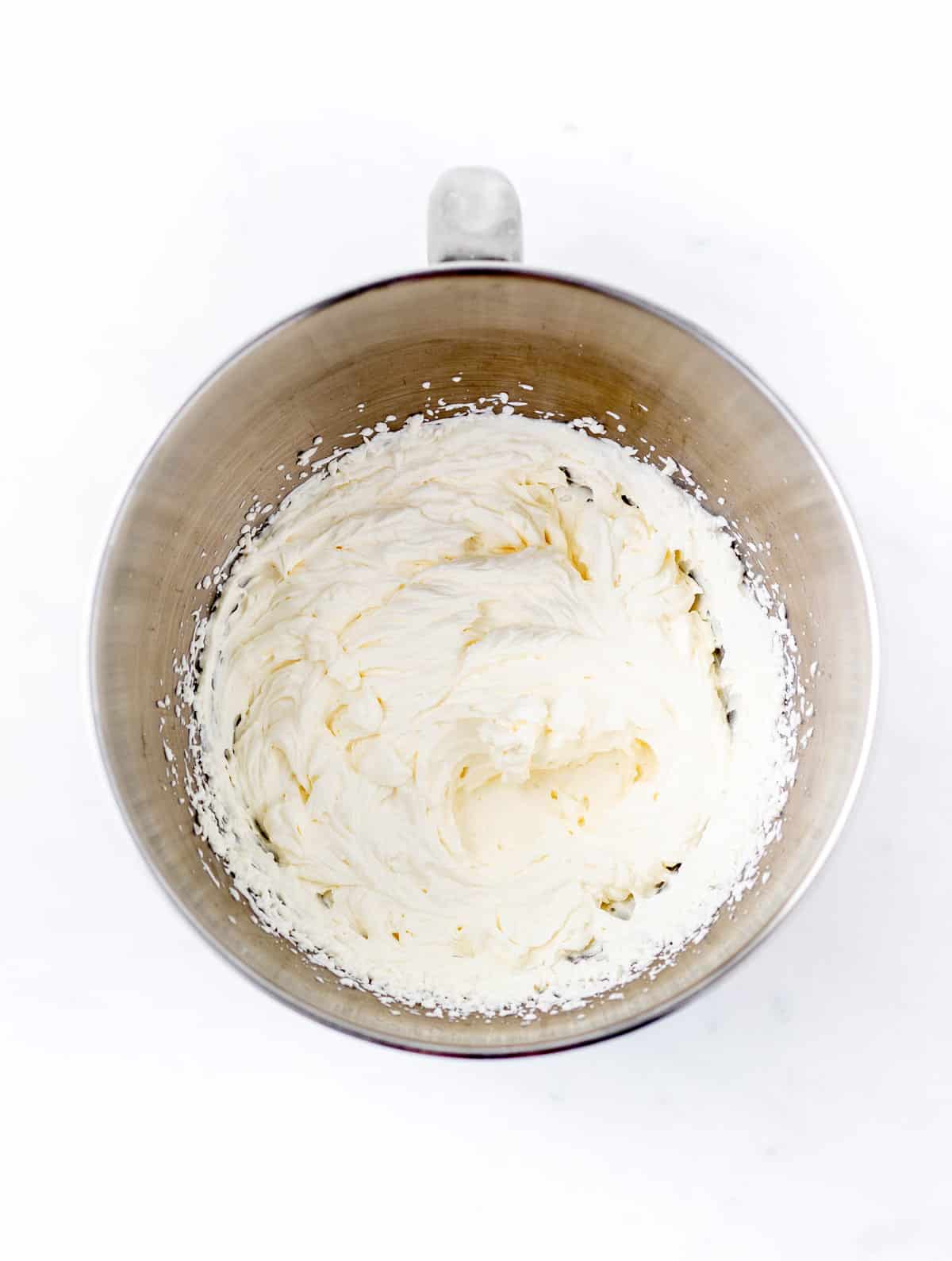 Homemade whipped cream in a large silver bowl.