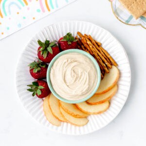 4-ingredient peanut butter dip in a small bowl with apples, strawberries and pretzels.