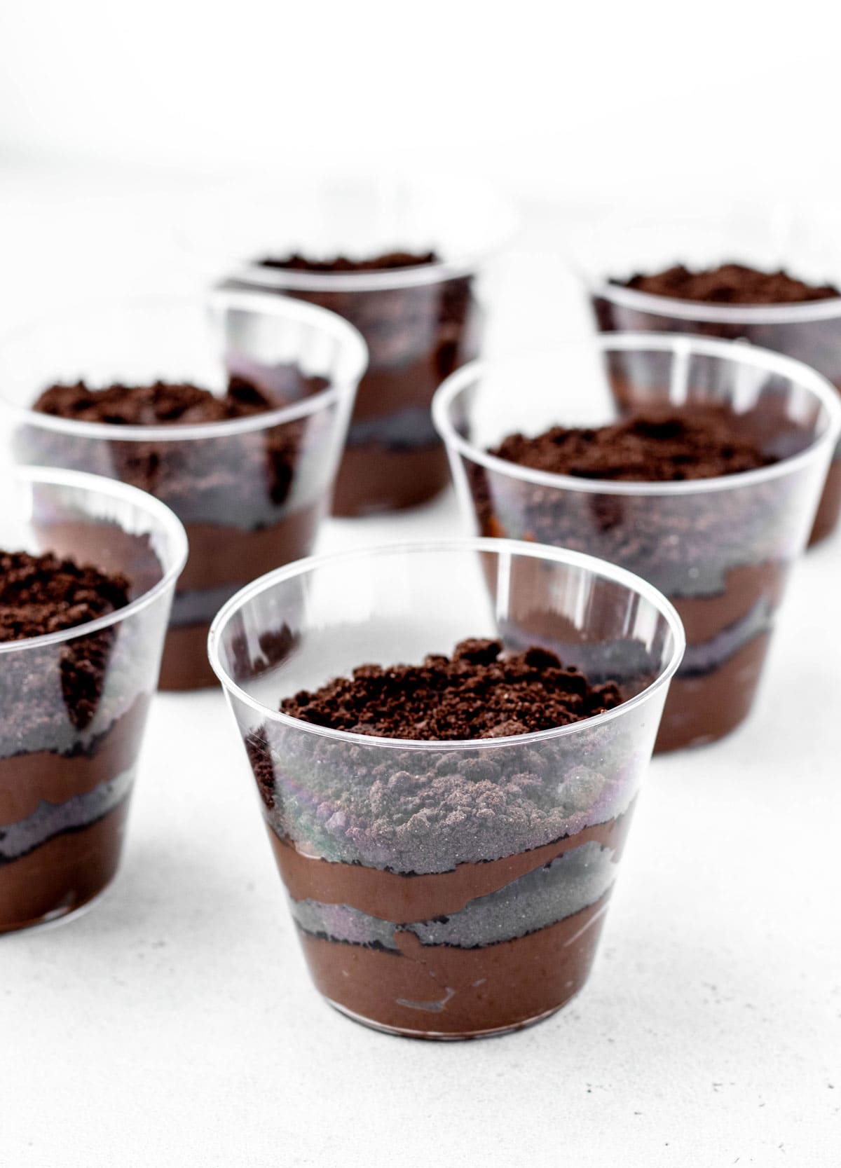 Oreo crumbs layered with chocolate avocado pudding in clear cups.