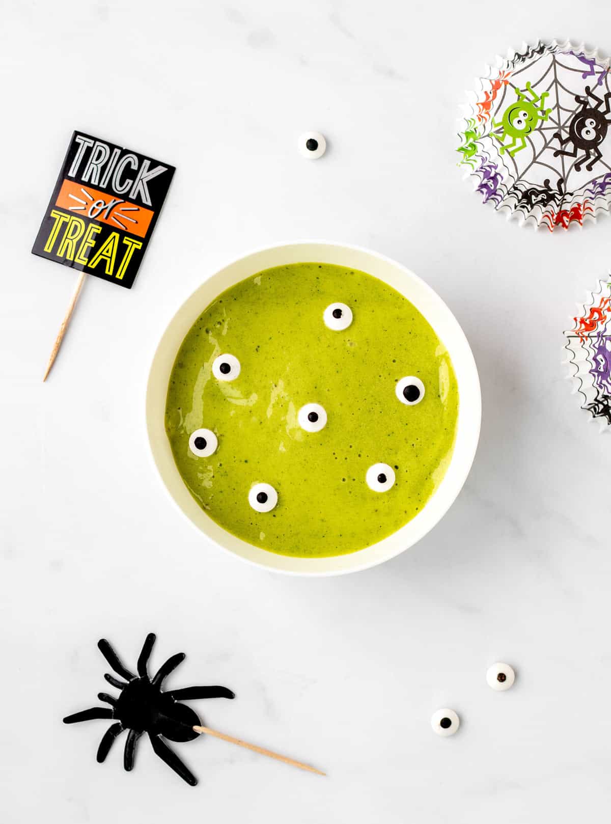 Green goblin smoothie bowl with Halloween decorations.
