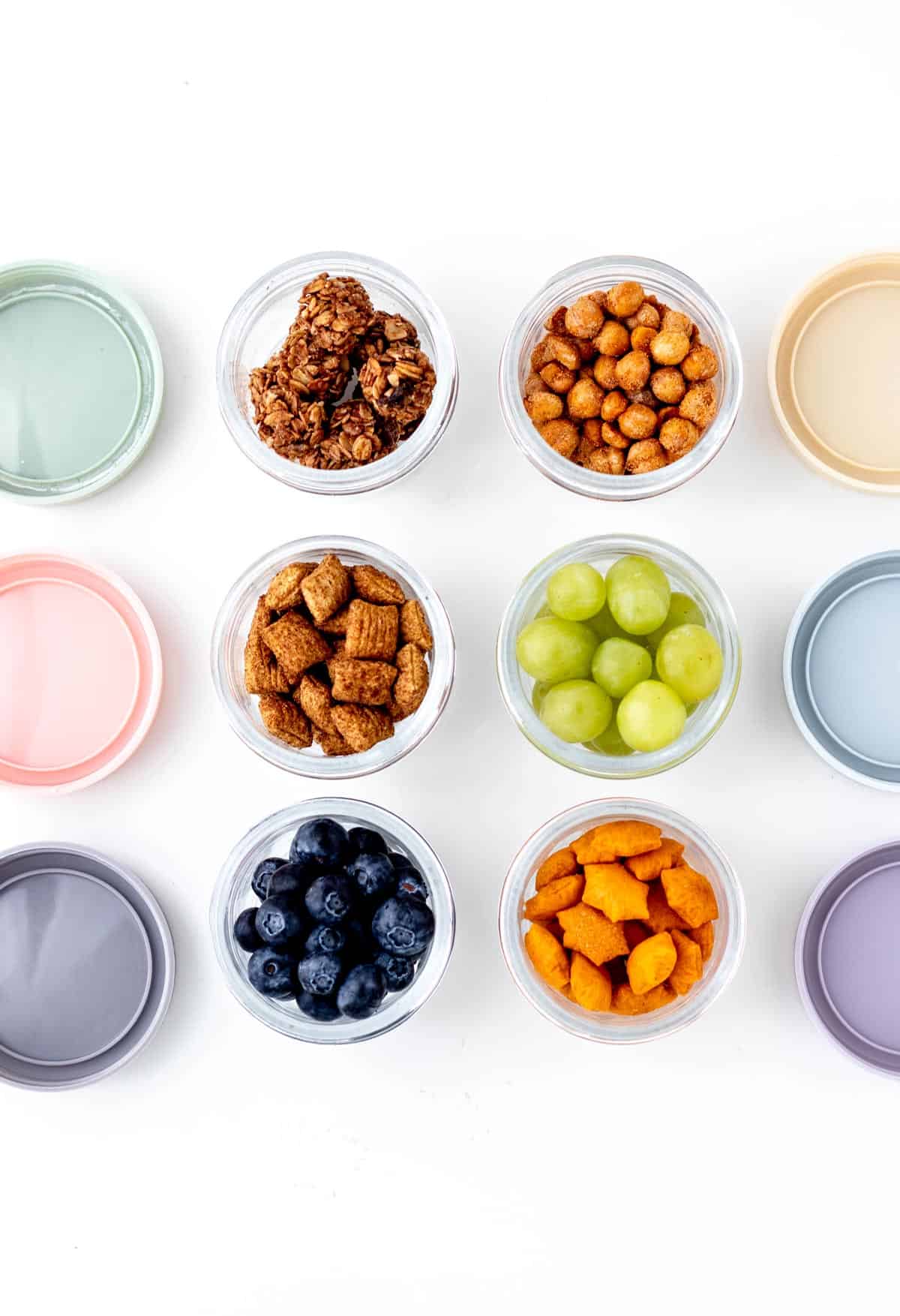 Overhead shot of easy road trip snacks packed in little containers with lids.
