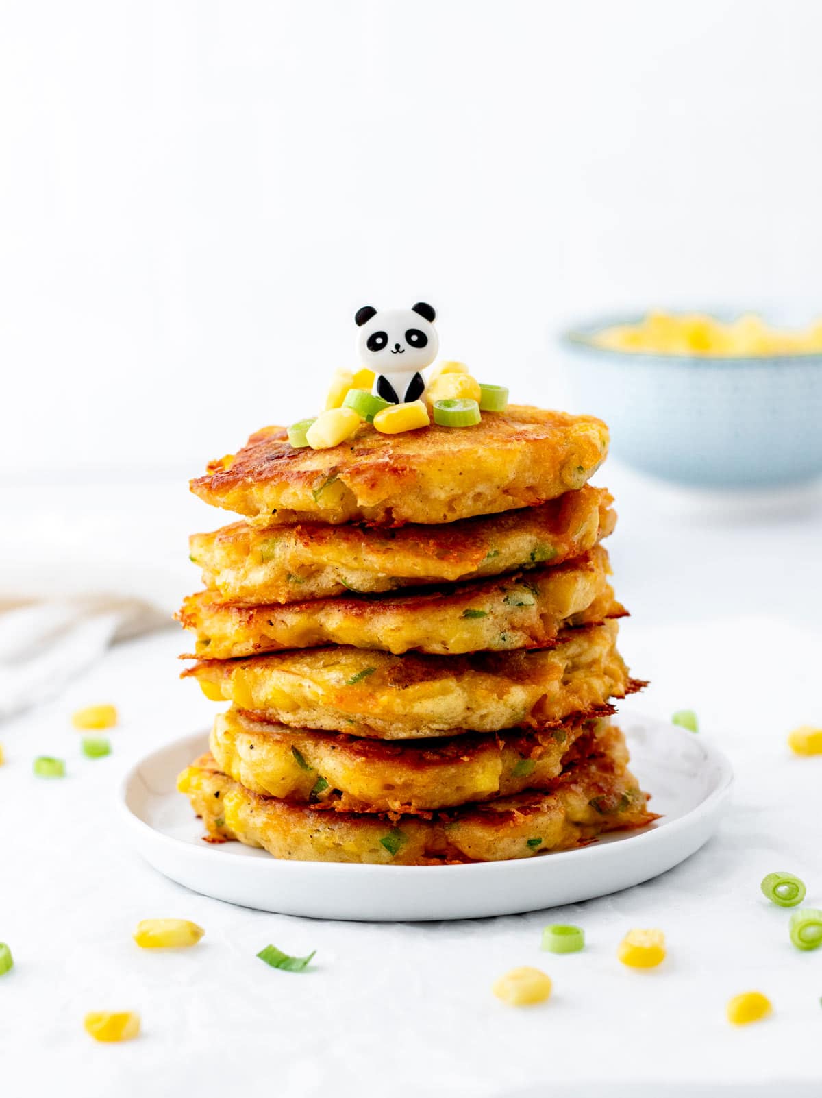 A stack of healthy corn fritters with a panda bear pick.