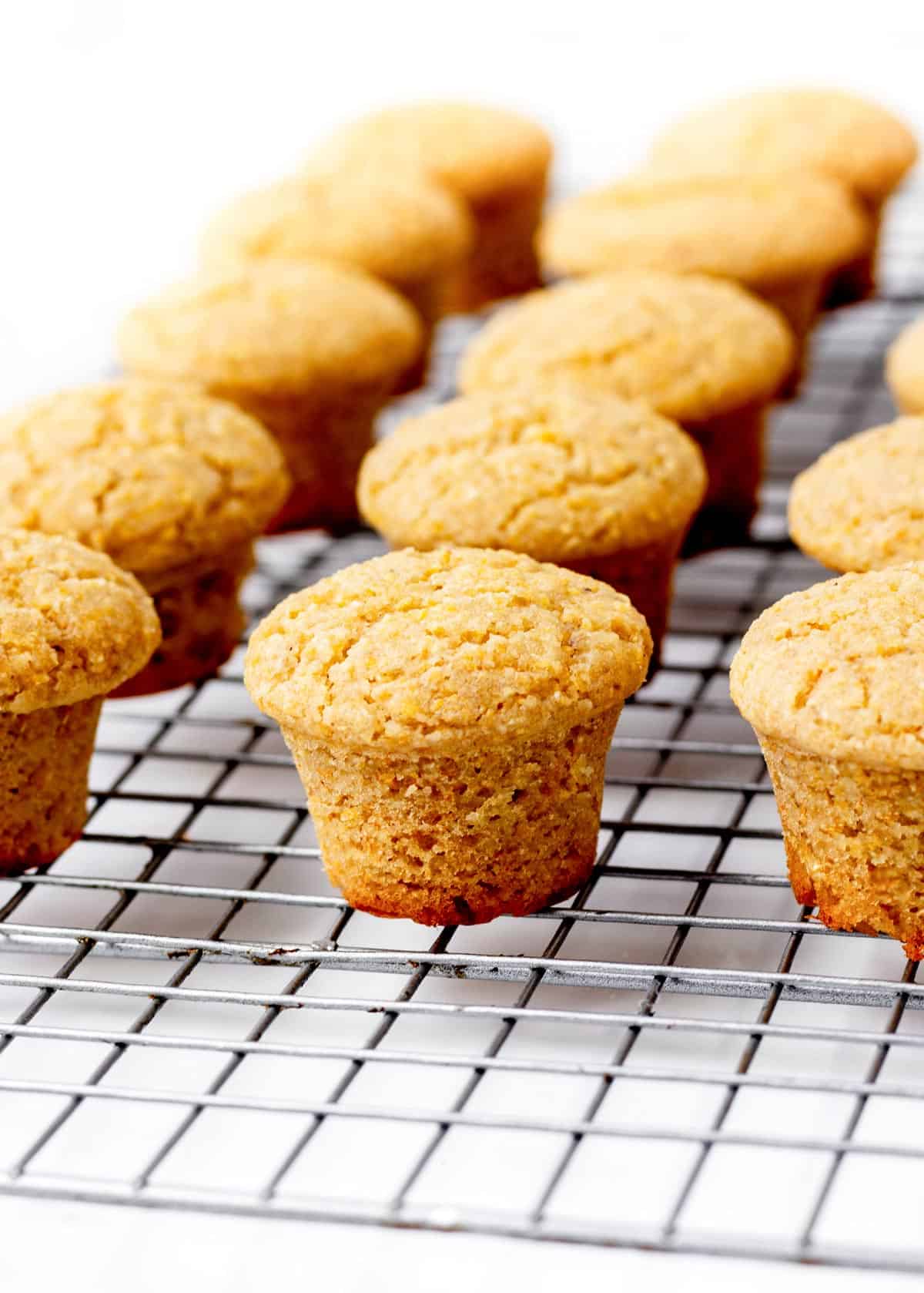 Mini honey cornbread muffins on a wire rack.