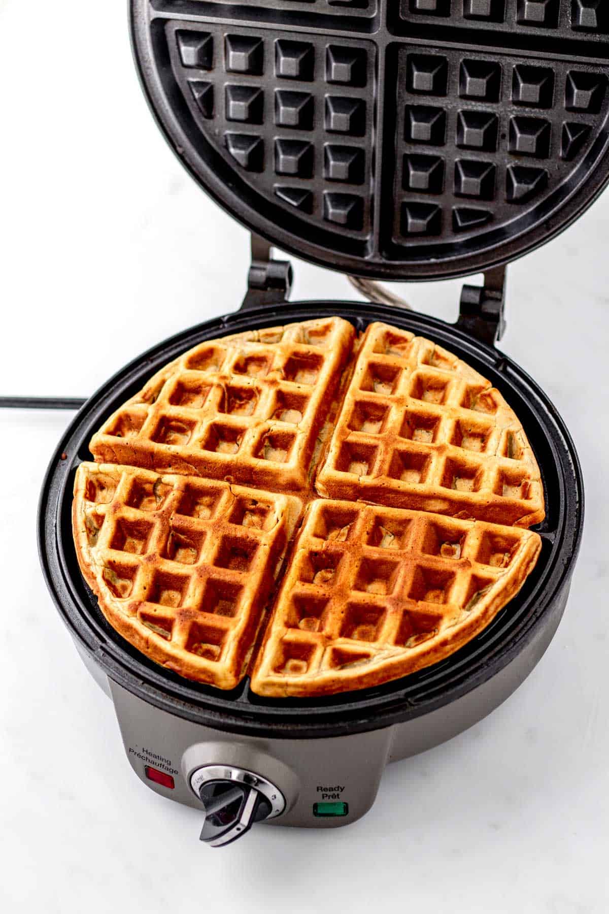 3-ingredient waffles cooking on a waffle iron.