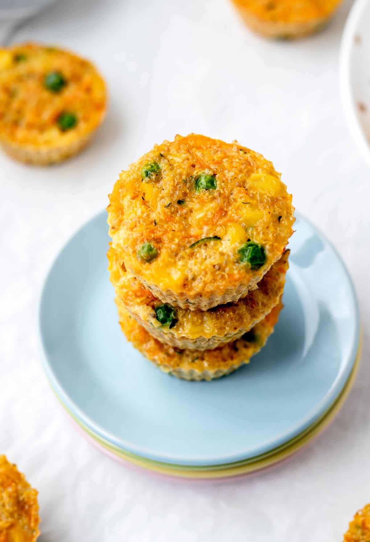 A stack of quinoa veggie bites on colorful plates.