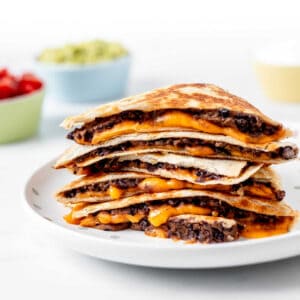 A stack of black bean and cheese quesadillas on a plate.