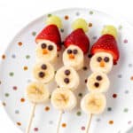 Three banana snowmen on sticks on a polka dot plate.