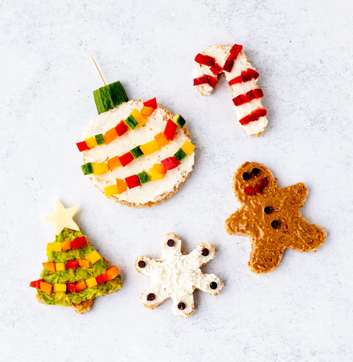 5 different holiday toast ideas: an ornament, candy cane, gingerbread man, snowflake and Christmas tree.