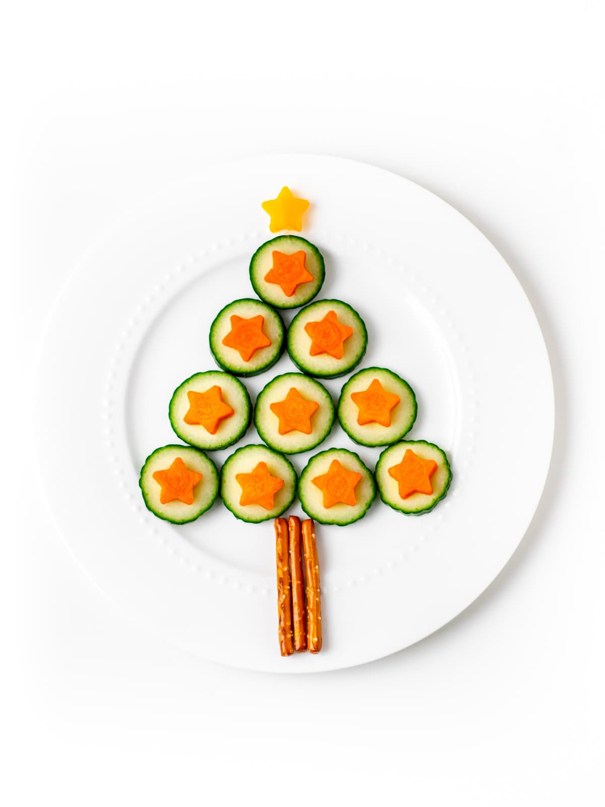Cucumber Christmas tree with carrot stars, pretzel trunk and yellow bellow pepper star on top.