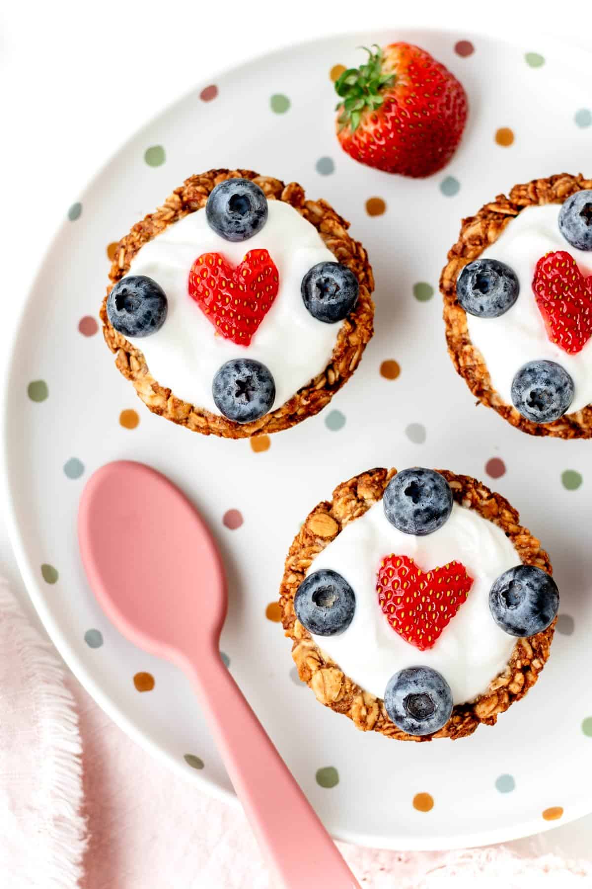 A birds-eye view of a few of the granola breakfast cups with yogurt and berries on top.
