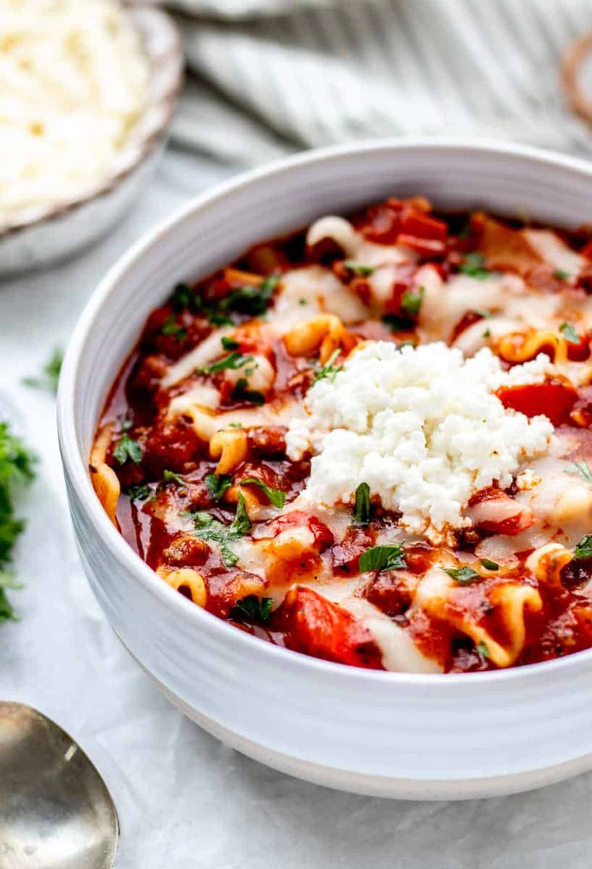 Lazy lasagna soup in a bowl topped with cheese.