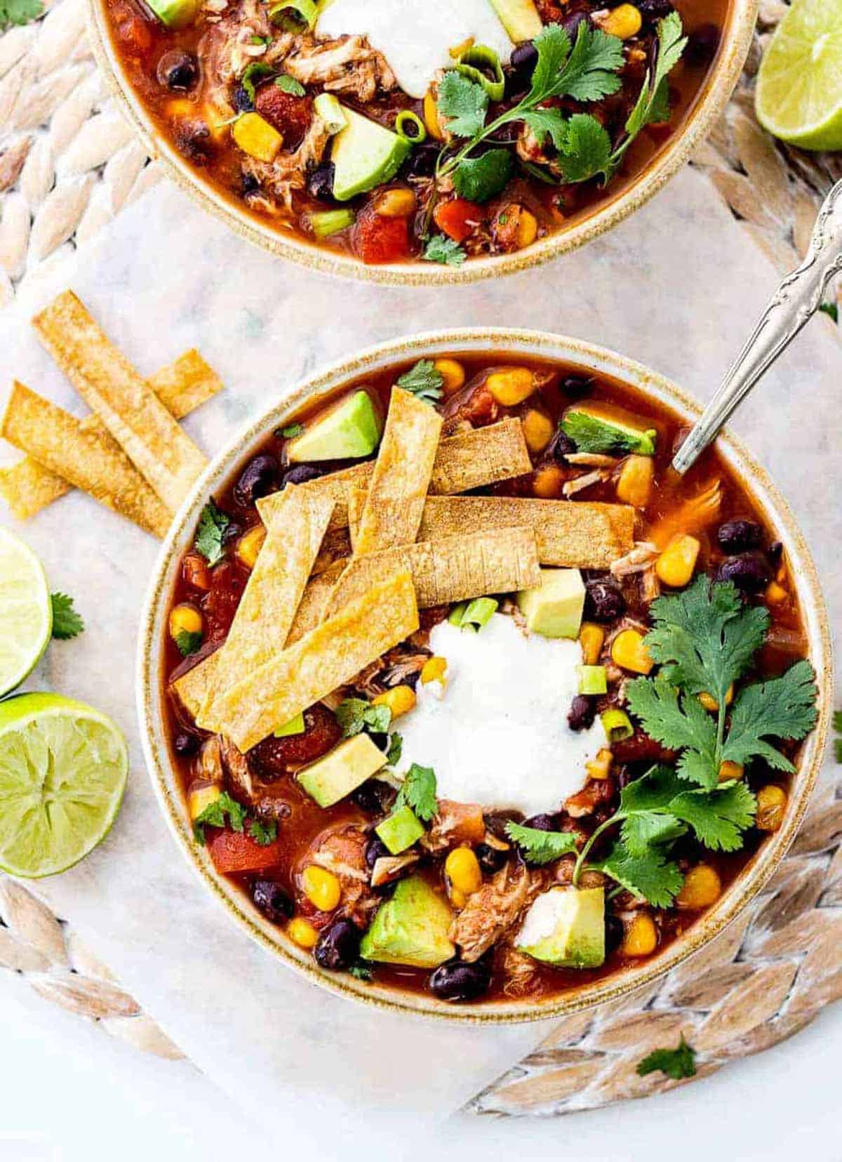 Healthy chicken tortilla soup in a bowl topped with tortilla strips.