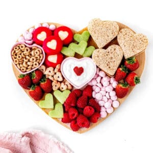 Heart shaped charcuterie board for kids on a white background.