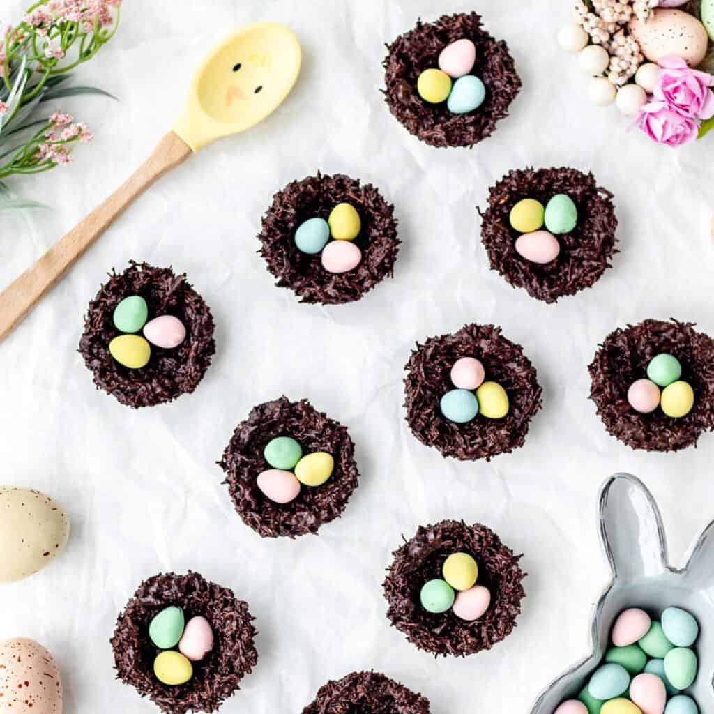 Chocolate shredded wheat Easter nests on a white background with Easter eggs.